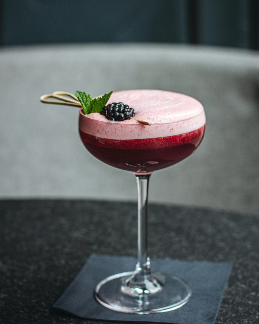 A blackberry sour in a coupe